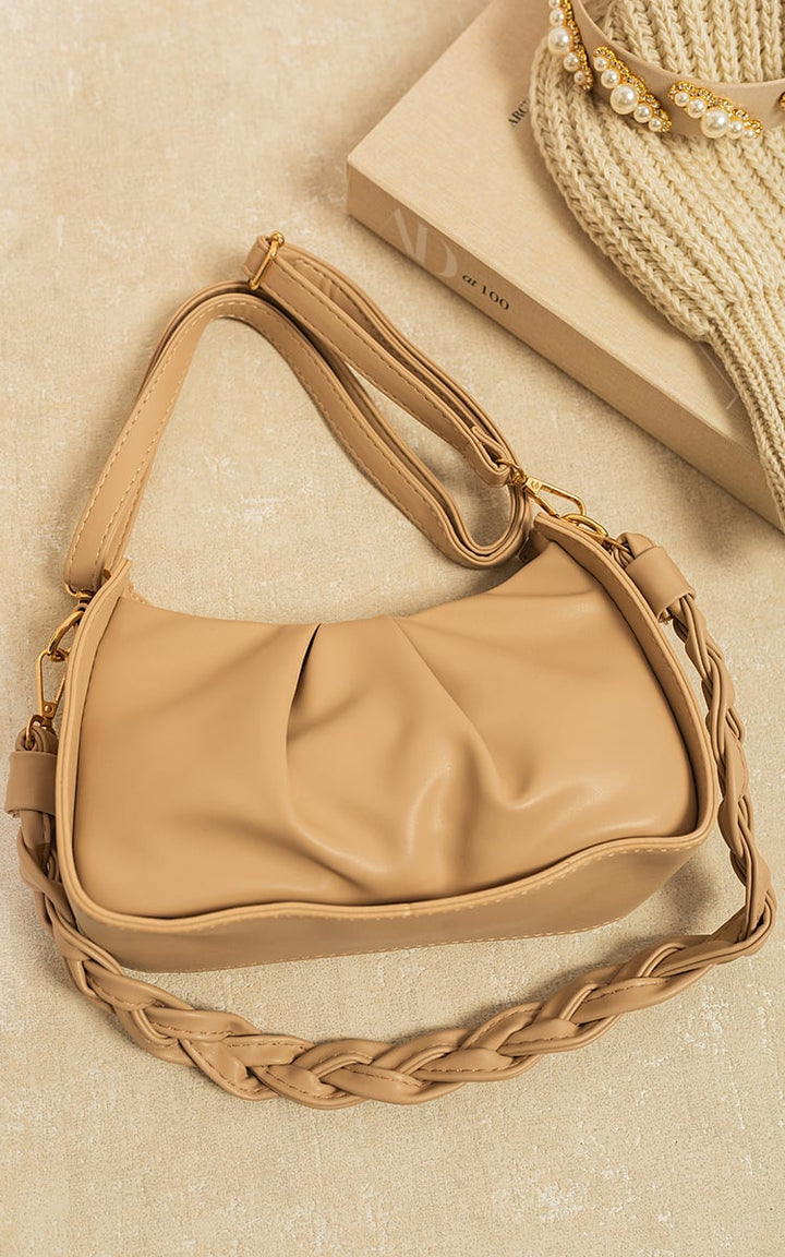 Ruched Faux Leather Shoulder Bag on a tan surface, showcasing its chic ruched design and spacious interior, ideal for versatile and stylish everyday use.