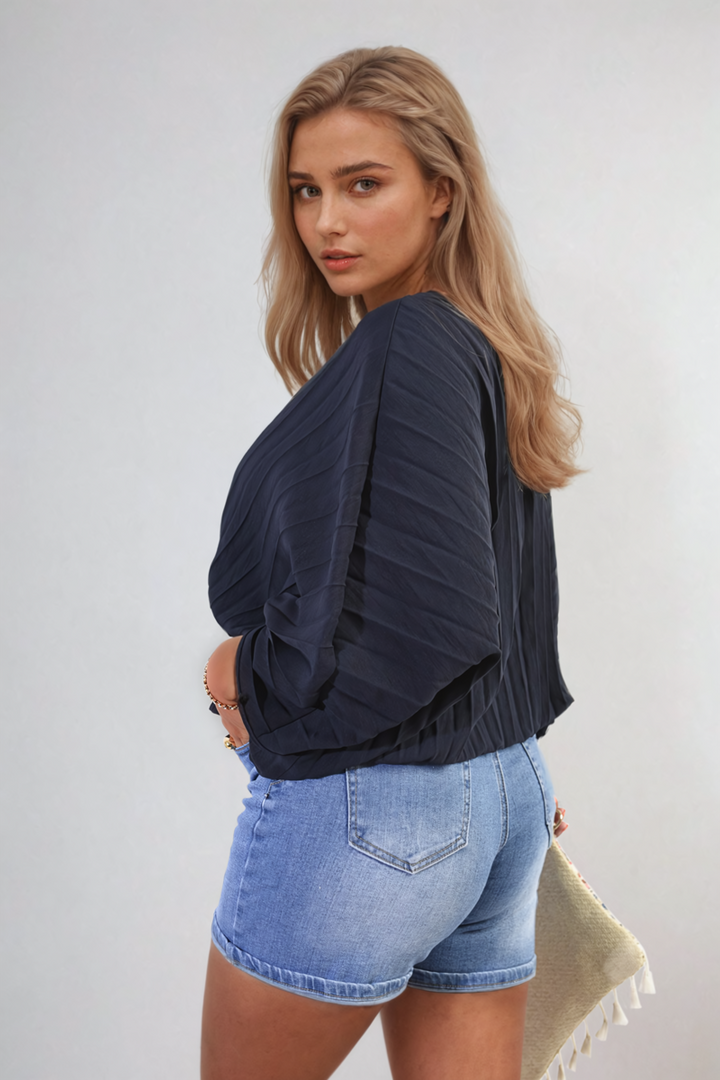 Woman modeling the Rowena Batwing Oversized Pleated Top, showcasing batwing sleeves and pleated details for a chic, versatile look.