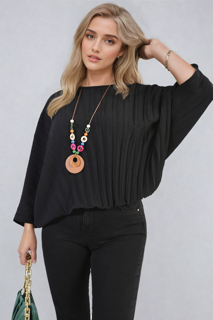 Woman wearing the Rowena Batwing Oversized Pleated Top, showcasing its chic batwing sleeves and pleated detailing, ideal for stylish and versatile everyday wear.