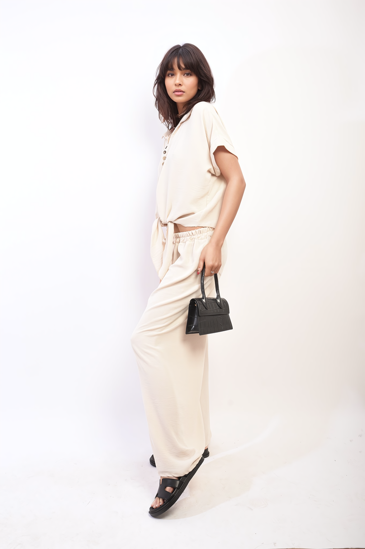 Woman wearing Tie Front Top and Wide Leg Pants Co-ord Set, holding a black purse, showcasing stylish and comfortable fashion from Holiday Clothes UK.