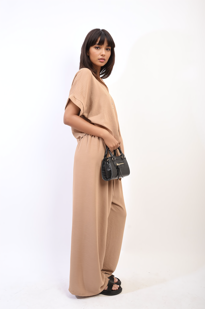 Woman in Tie Front Top and Wide Leg Pants Co-ord Set, holding a black purse, showcasing sophisticated style and comfort from Holiday Clothes UK.