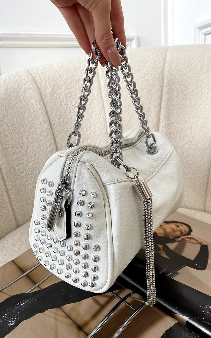 Studded with Chain Detail Handbag held in a hand, showcasing its faux leather material and silver stud embellishments, perfect for adding luxury to any outfit.