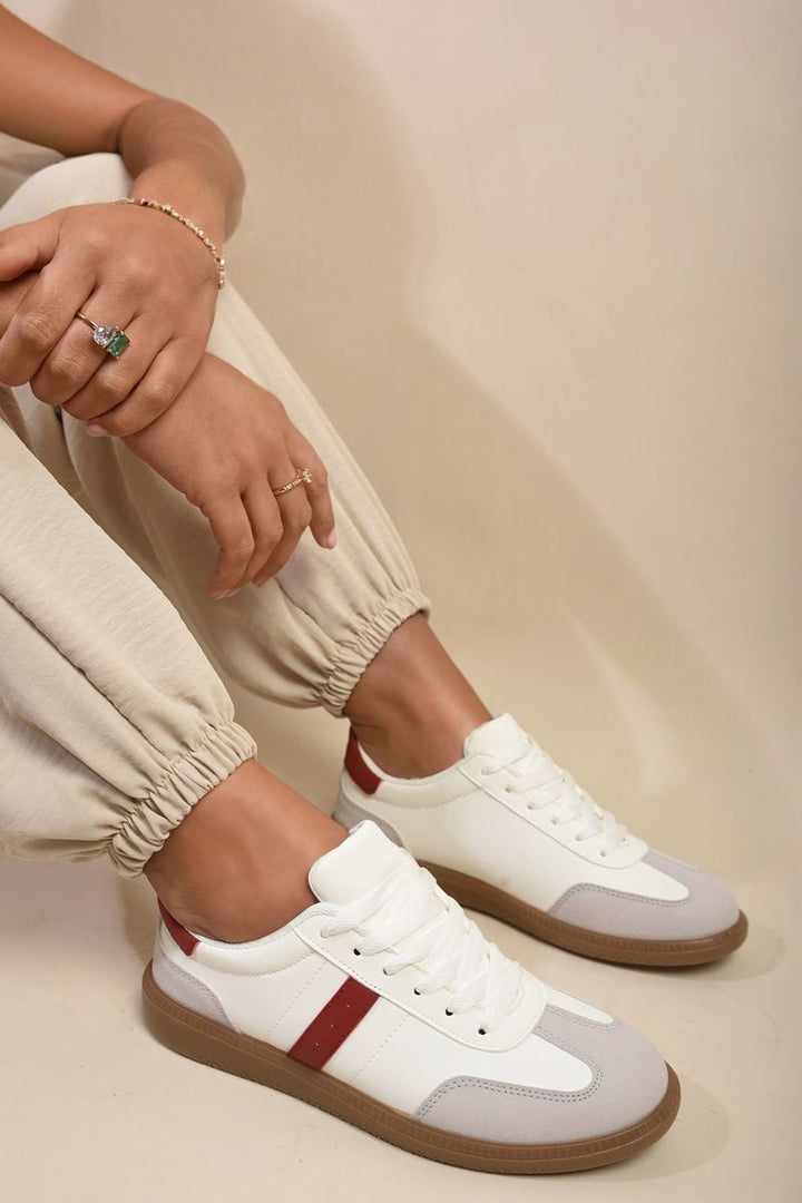 A person wearing Sabrina Low Top Lace-Up Trainers, showcasing their classic low-top design and casual style.