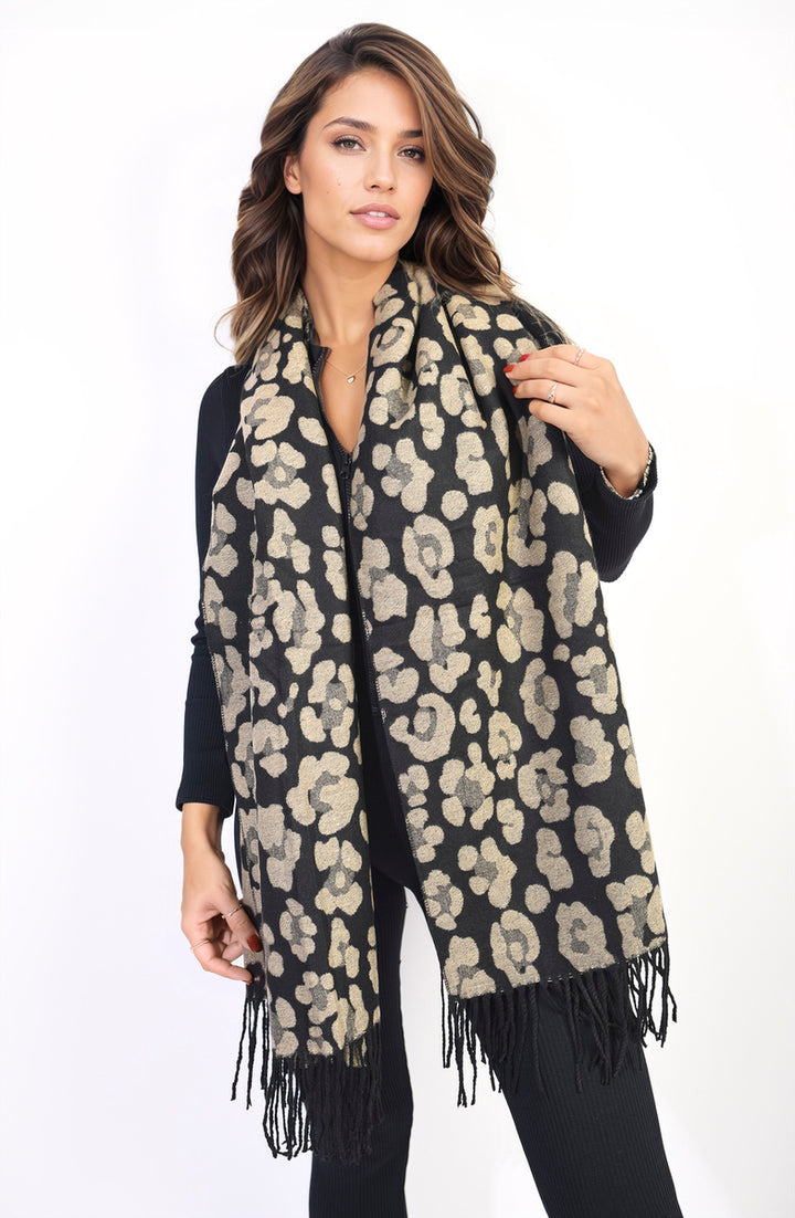 Woman wearing the Saira Animal Print Scarf with Tassel, showcasing its bold design and playful tassels, perfect for stylish holiday and everyday wear.