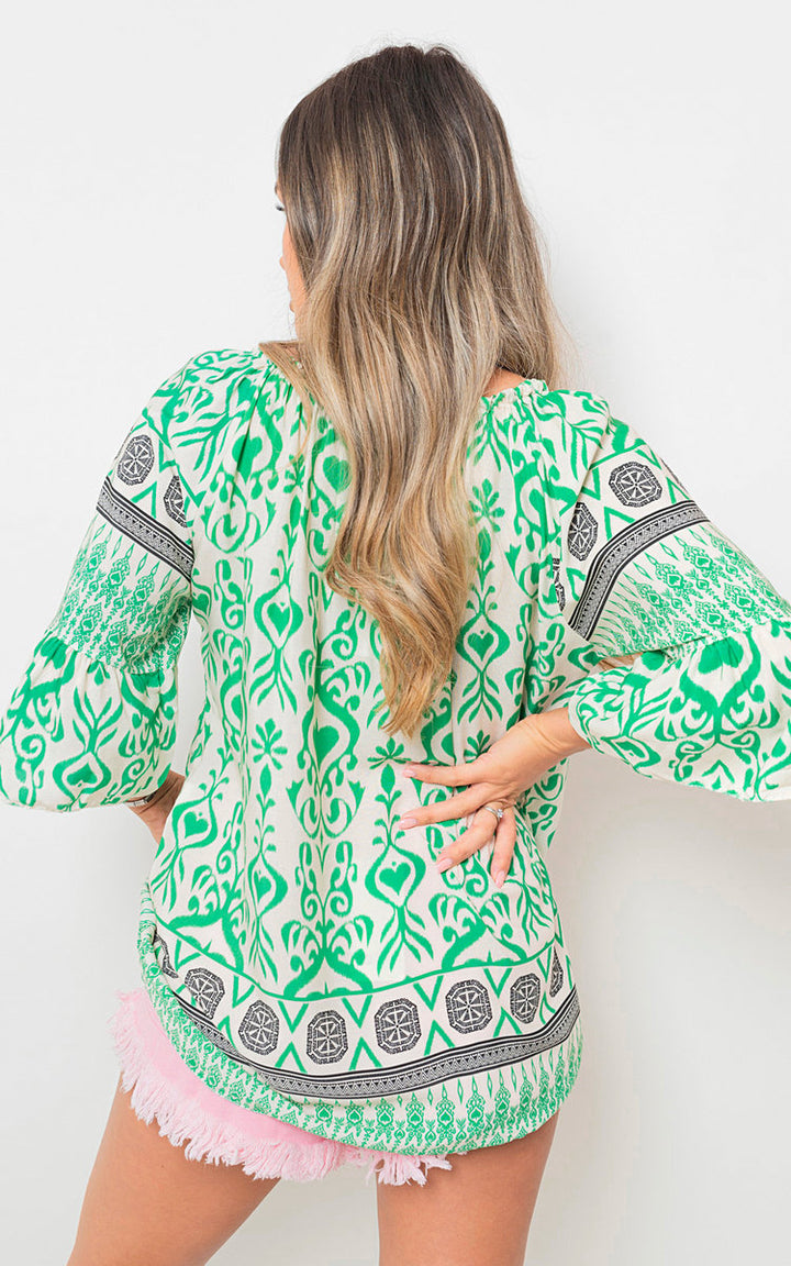 Boho Printed Tassel Tie Neck Long Sleeve Loose Top worn by a woman, showcasing its bohemian print and tassel details.