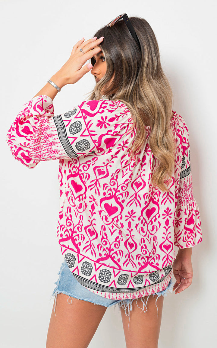 Boho Printed Tassel Tie Neck Long Sleeve Loose Tops modeled by a woman, showcasing bohemian style with vibrant patterns and tassel details.