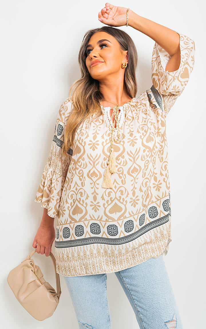 Boho Printed Tassel Tie Neck Long Sleeve Loose Top with intricate patterns, worn by a woman, showcasing the tassel detail and flowy silhouette.