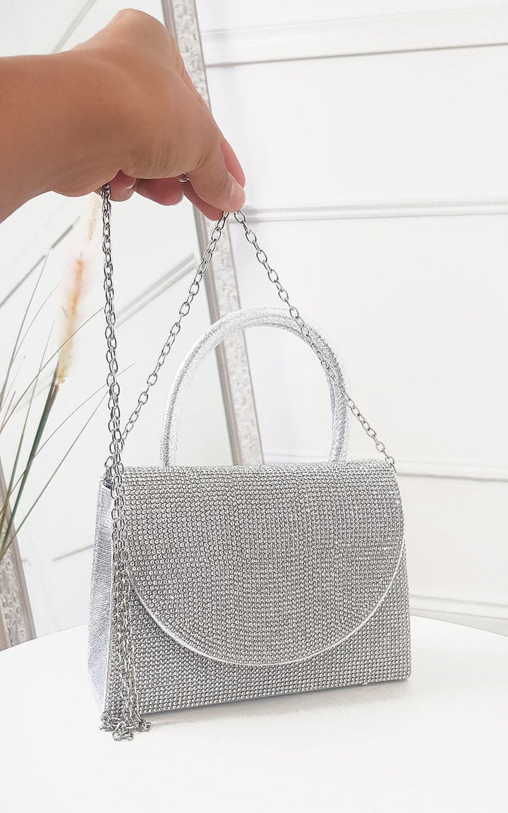 Diamante Embellished Handbag with silver chain, metallic shine, and magnetic closure, held in a hand, showcasing its compact and stylish design.