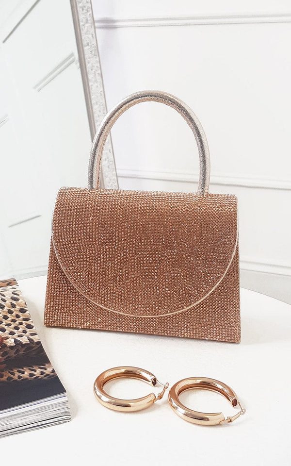 Diamante Embellished Handbag with silver handle and detachable strap, shown alongside gold hoop earrings on a table.