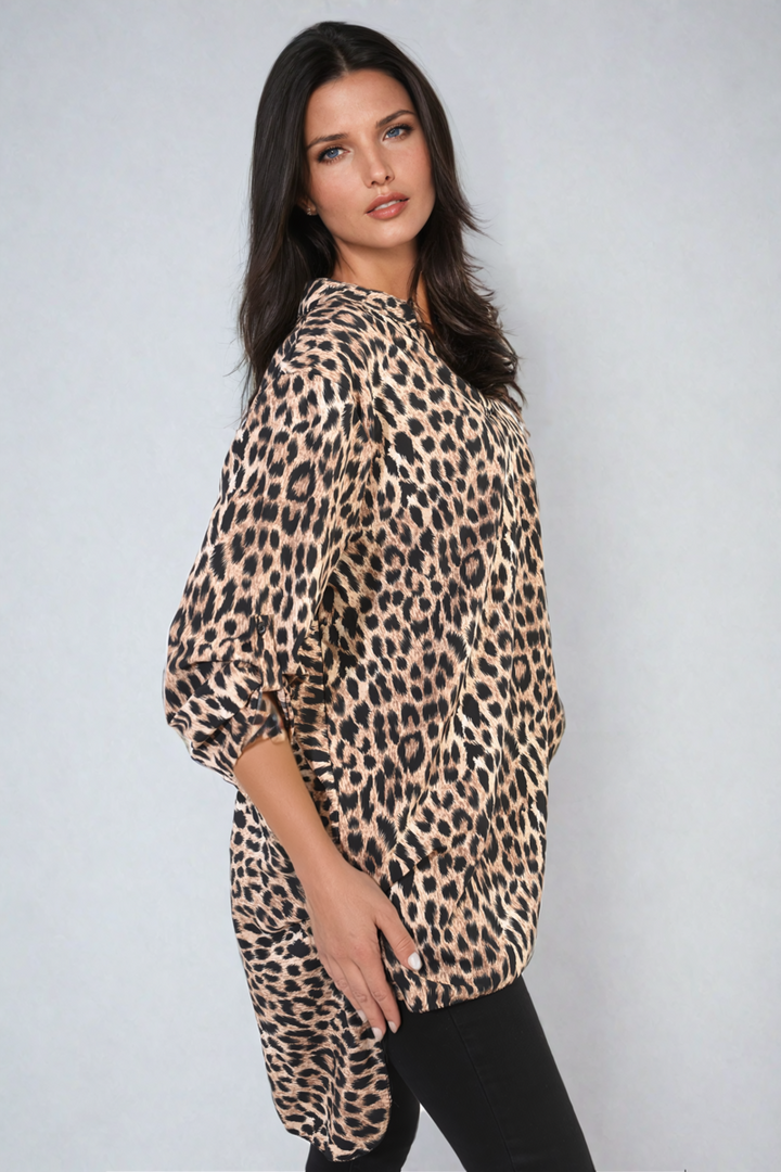 Woman wearing an oversized leopard print button-down top with batwing sleeves, exemplifying a relaxed and trendy style, ideal for casual outings or nights out.