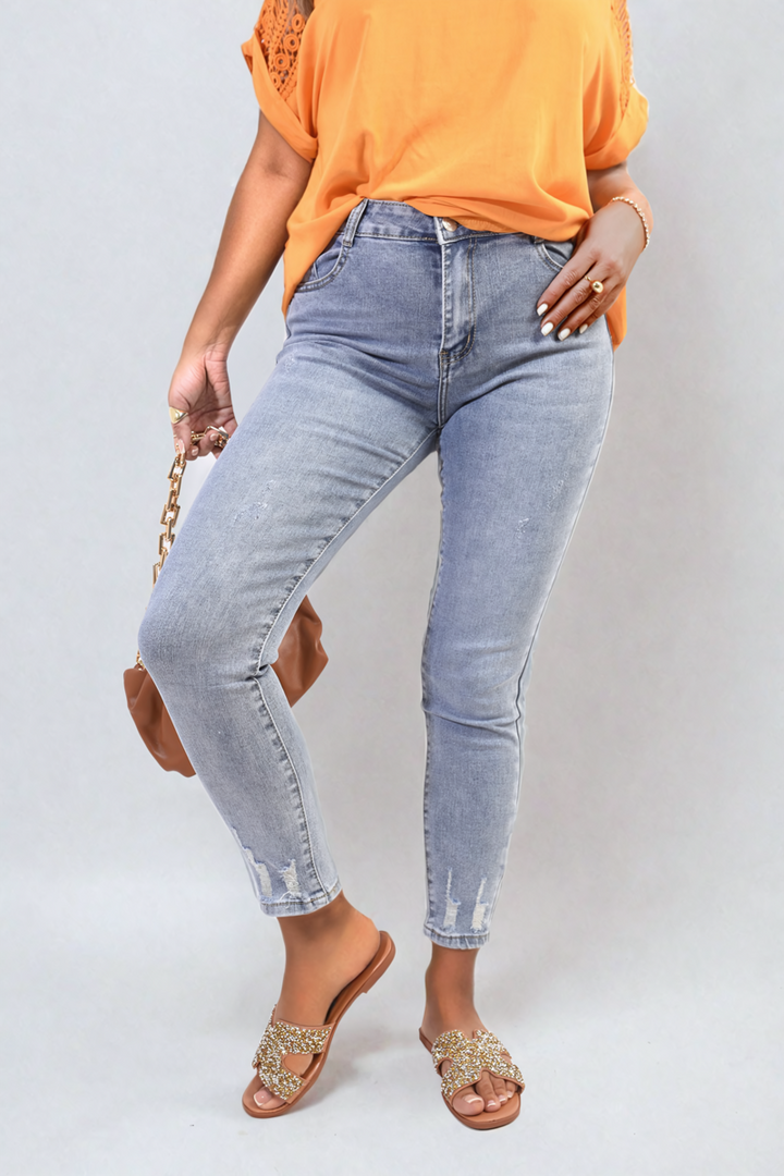 Woman wearing Sevyn Distressed High Waisted Jeans, featuring stylish distressing and a flattering fit, paired with brown rhinestone sandals. Chic casual look for everyday wear.