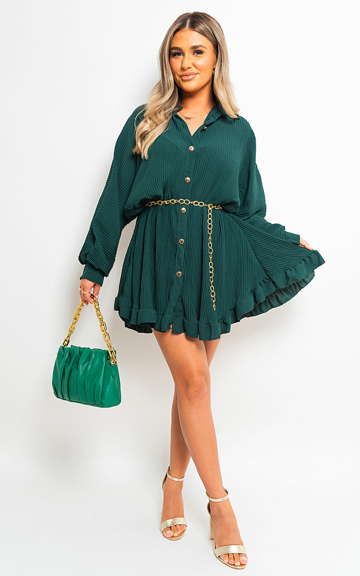 Woman in Long Sleeve Pleated Button Up Mini Dress, accessorized with a green purse and gold chain, showcasing a chic, versatile style perfect for any occasion.