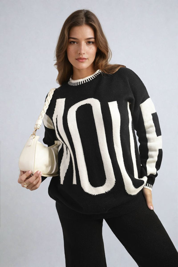 Amour Graphic Long Sleeve Knitted Jumper modeled by a woman, highlighting its cozy knit fabric and stylish design, perfect for casual wear.