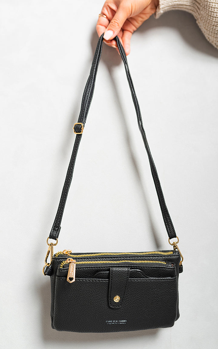 Small Multifunctional Leather Shoulder Bag with adjustable strap and gold clasps, hanging on a hook, showcasing its compact design and stylish functionality.