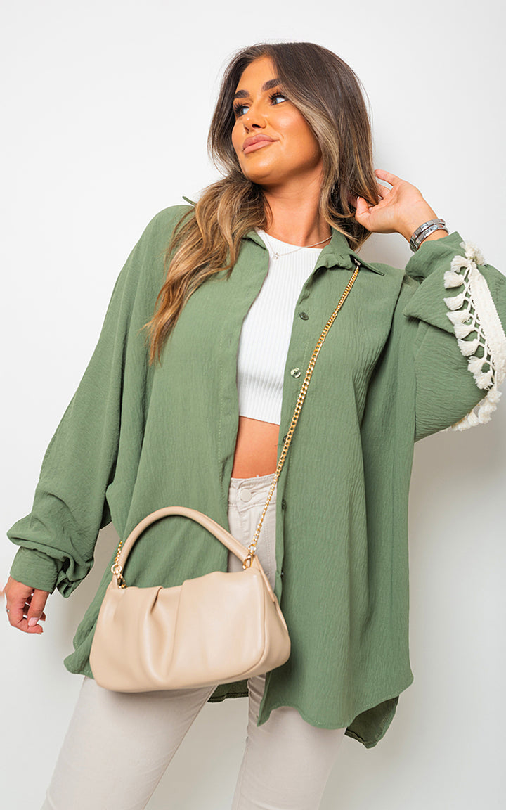 Vanessa Oversized Long Sleeve Tassel Trim Top features an oversized fit with tassel details, showcasing boho charm. Ideal for stylish, comfortable holiday wear.