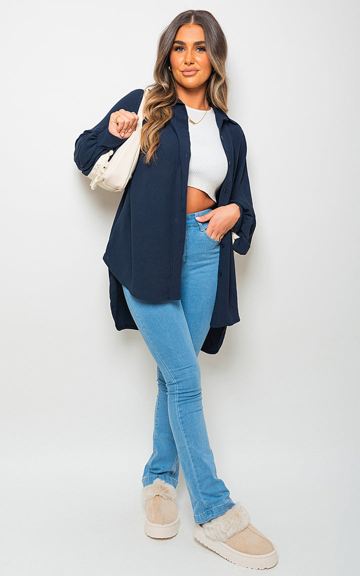 Oversized Long Sleeve Tassel Trim Top showcased by a woman wearing blue jeans, highlighting its boho-inspired oversized fit and playful tassel details.