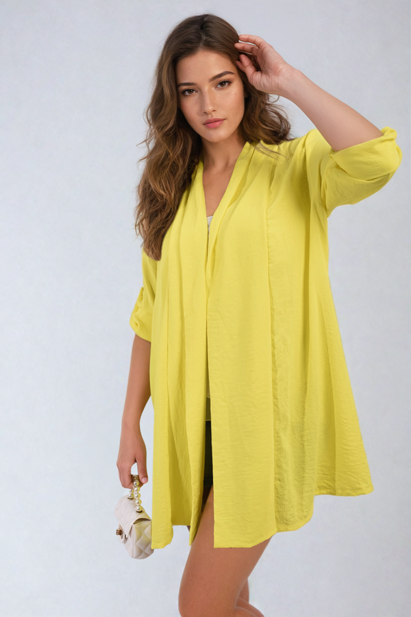 Woman in yellow dress modeling Vivian Open Front Roll Up Sleeve Cardigan, showcasing its stylish open design and versatile roll-up sleeves.