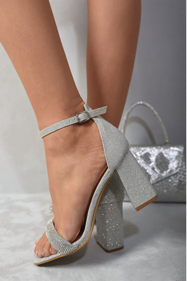 Silver Rhinestone Ankle Strap Block High Heels on foot, featuring dazzling rhinestones and a comfortable block heel, perfect for adding glam to any holiday outfit.