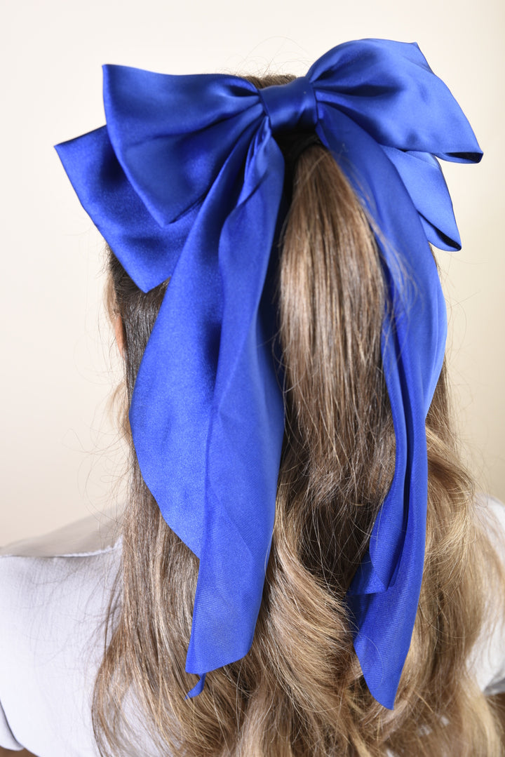 Elegant Big Bow Hair Clips adorning a woman's hairstyle; a chic accessory from Holiday Clothes UK, perfect for adding sophistication and charm to any look.