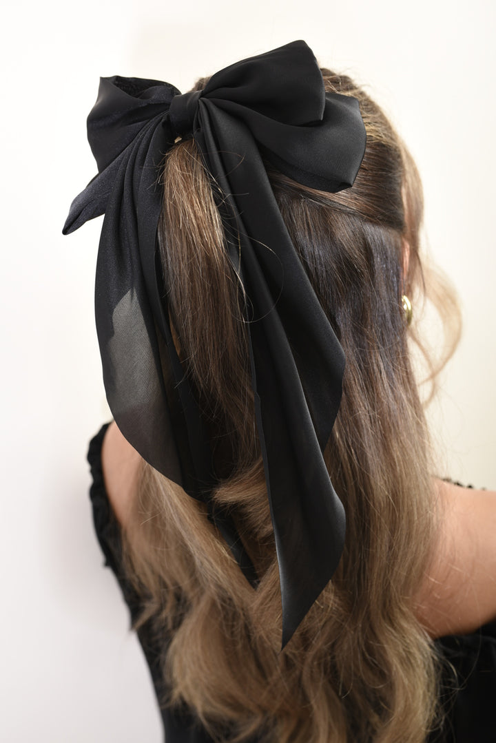 Woman wearing the Elegant Big Bow Hair Clip, showcasing a chic and sophisticated hairstyle accessory from Holiday Clothes UK.