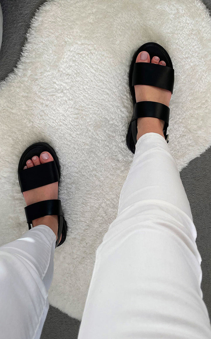 Chunky Sandals with sporty luxe sole and chunky straps, shown on a person wearing white pants, ideal for styling with jeans or a smock dress.