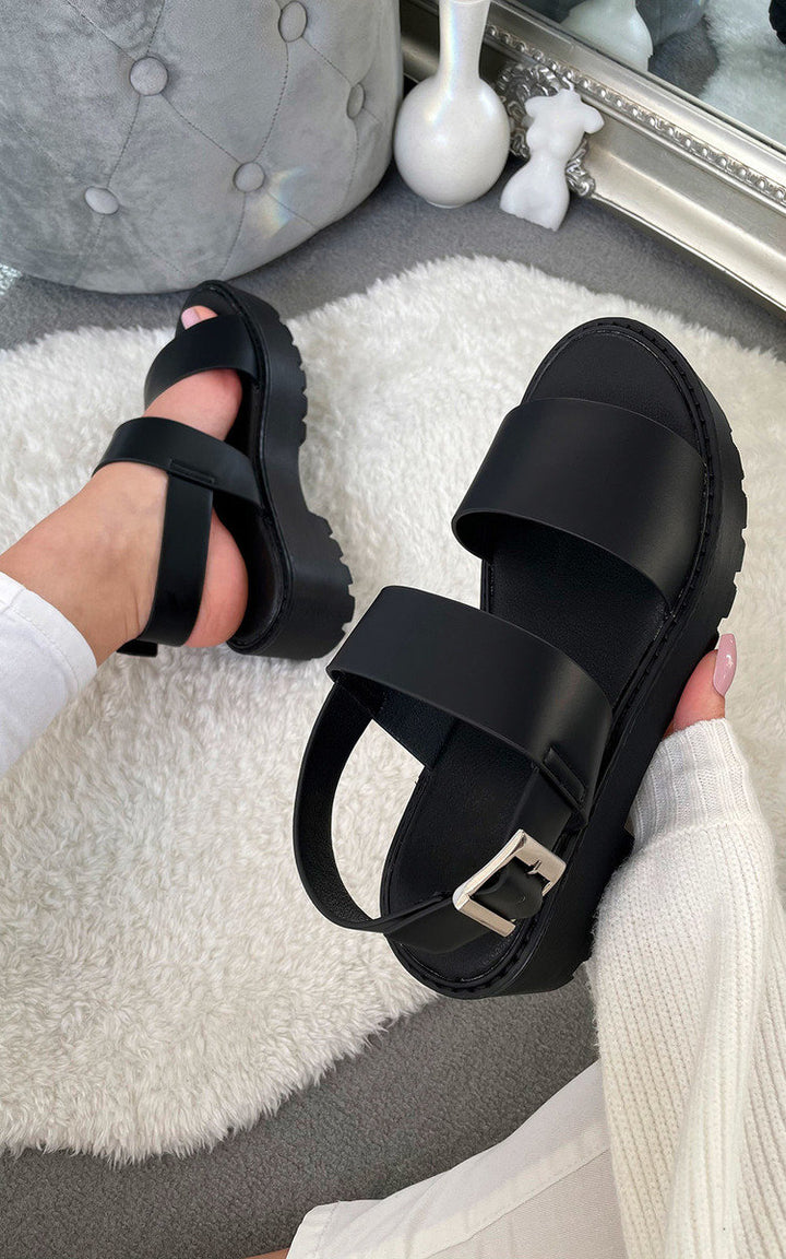 Person holding Chunky Sandals with sporty luxe chunky sole and straps, ideal for styling with jeans or a smock dress for festivals.