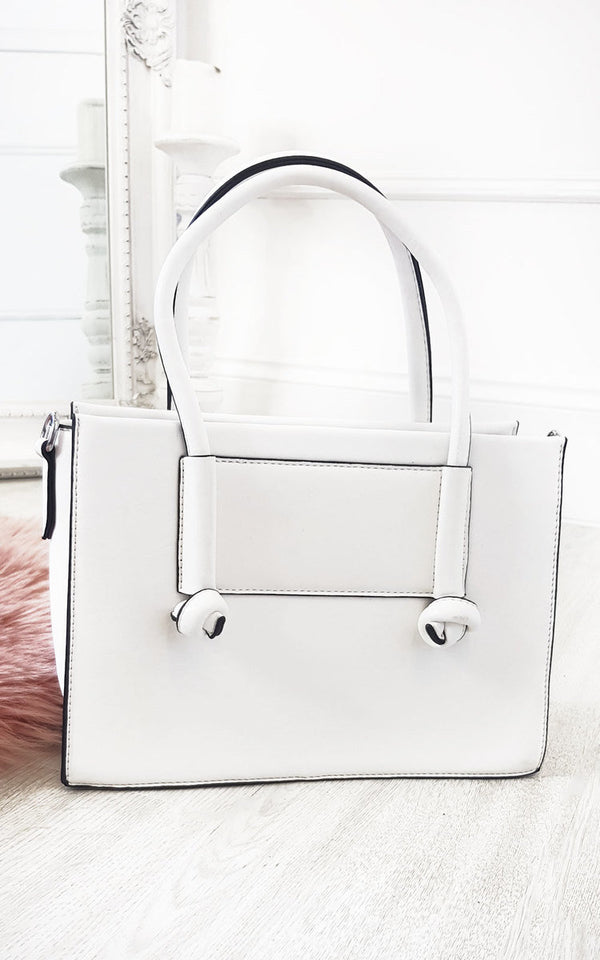 Faux Leather Handbag with zip fastening, handheld and detachable shoulder straps, featuring silver hardware and multiple inner compartments, displayed on a floor.