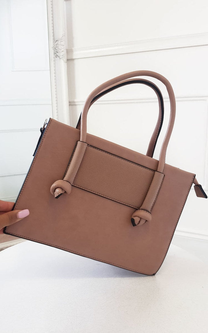 Hand holding a Faux Leather Handbag with zip fastening and silver hardware, featuring handheld and detachable shoulder straps.