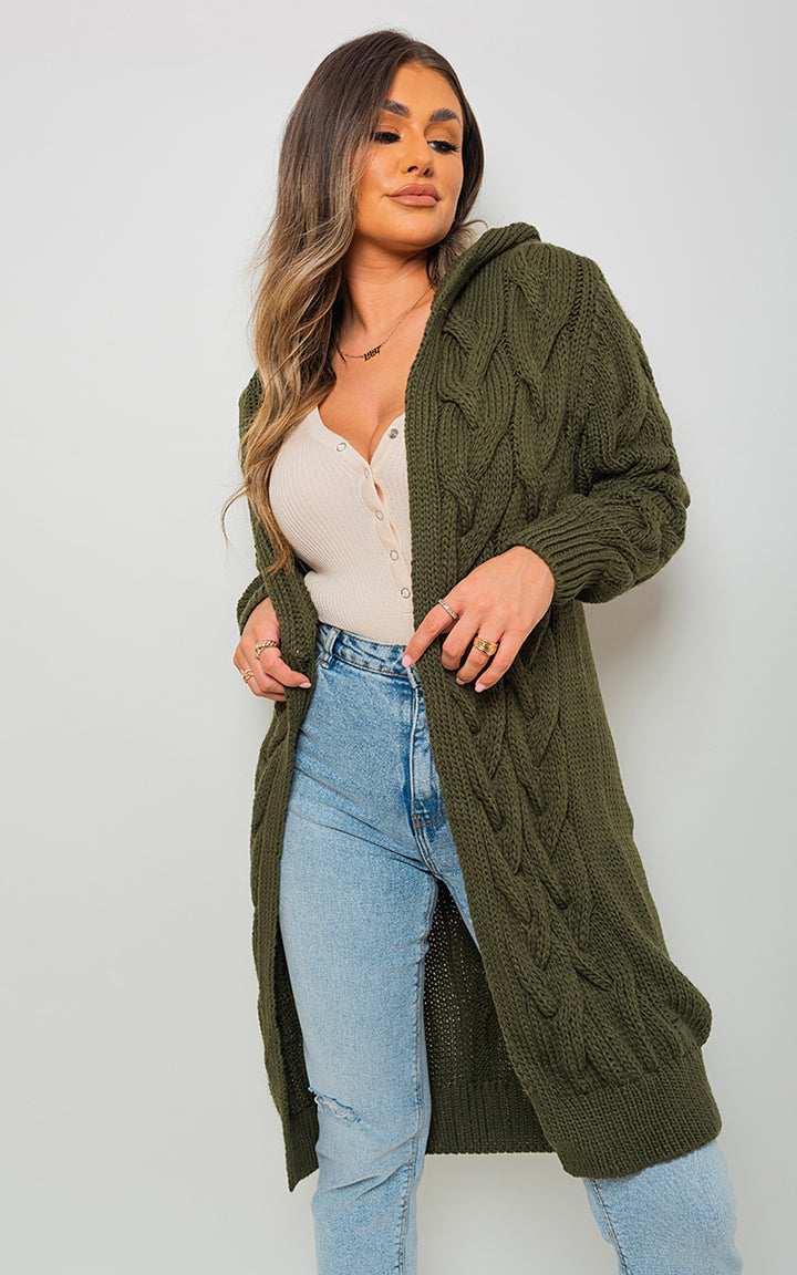 Woman wearing a Chunky Cable Knitted Oversized Longline Hooded Cardigan, ideal for layering and casual wear. Perfect for cozy days from Holiday Clothes UK.