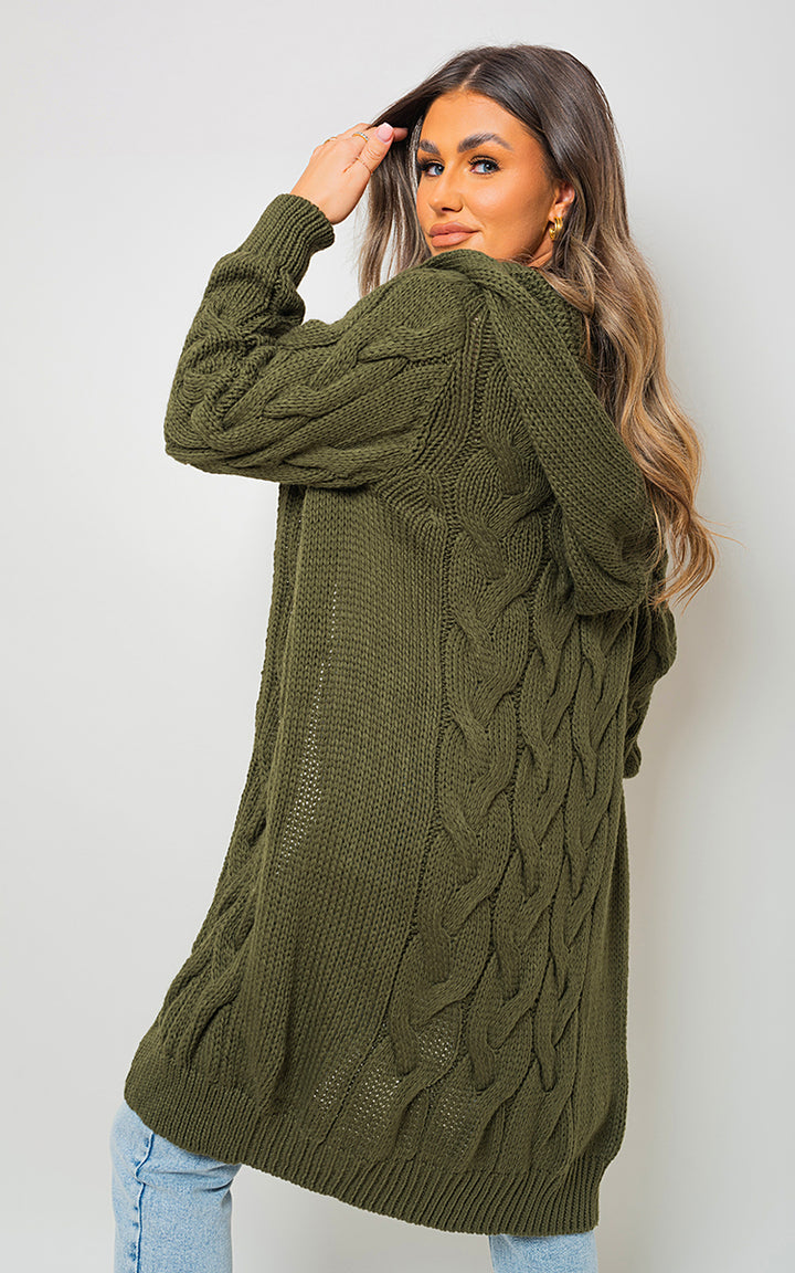 Chunky Cable Knitted Oversized Longline Hooded Cardigan worn by a woman, showcasing its cozy, longline design perfect for layering. Ideal for stylish, everyday wear.