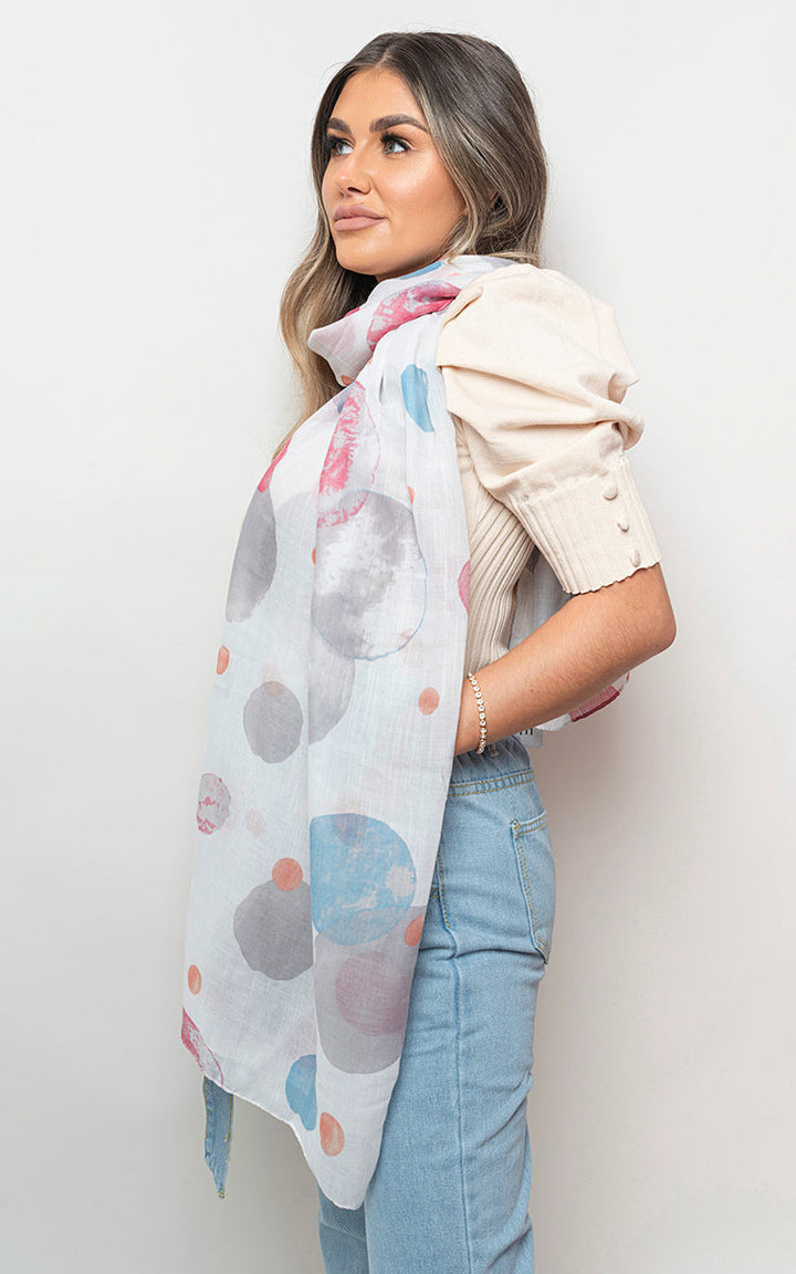 Woman wearing the Zoe Summer Wrap Scarf with Printed Large Polka Dots, showcasing its playful polka dot pattern and versatile styling options.